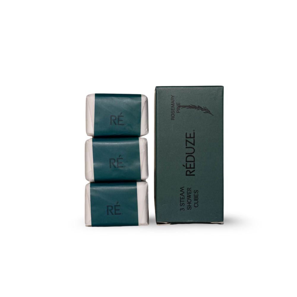 Tre cubi doccia e una scatola verde con logo "RÉDUZE". Testo: "ROSEMARY PINE" e "3 STEAM SHOWER CUBES".