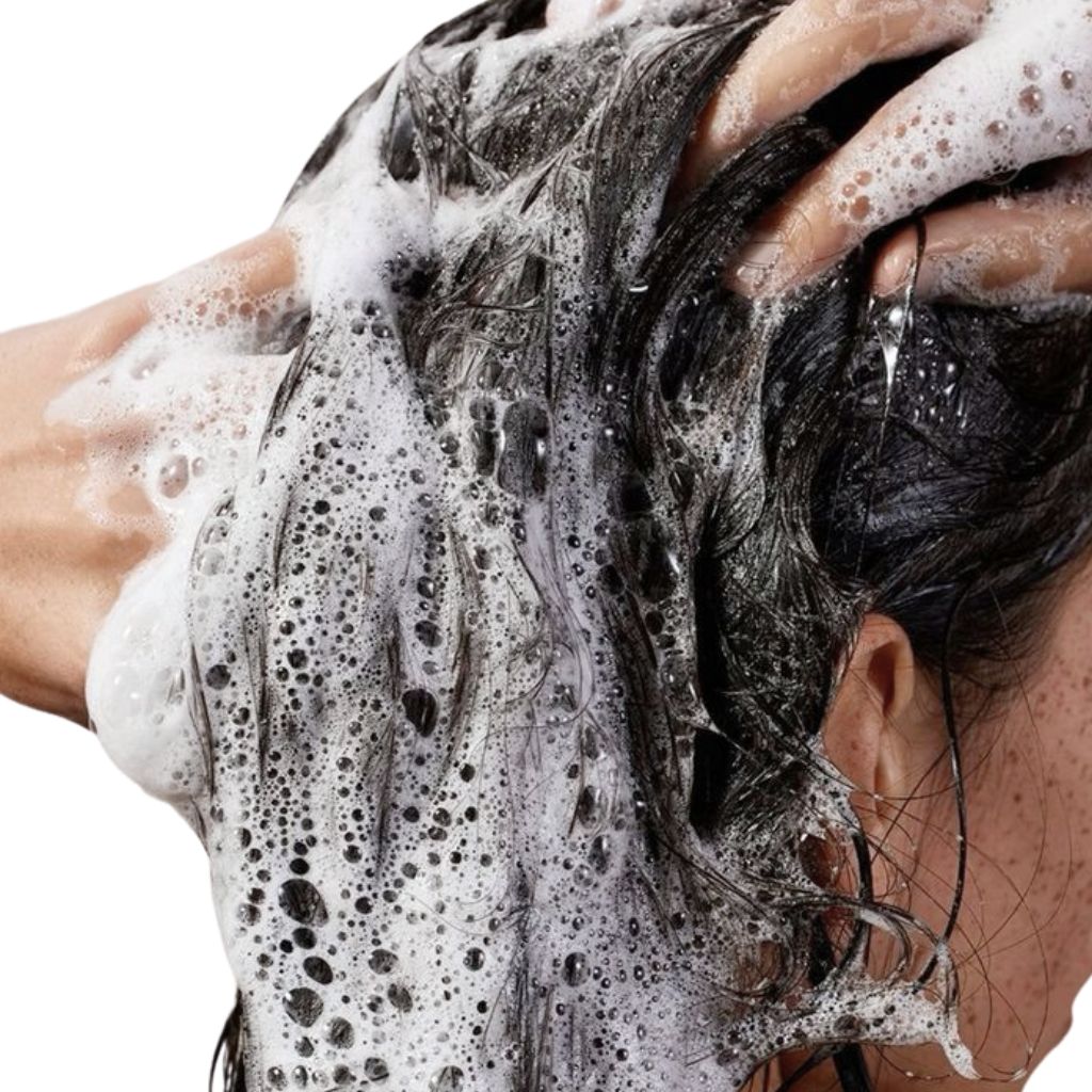 Persona che si lava i capelli con la schiuma. Capelli coperti di schiuma.