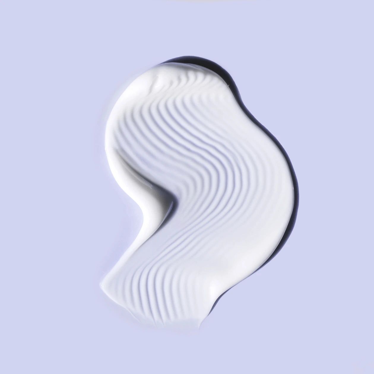 Macchia di crema bianca su sfondo azzurro. Texture ondulata.