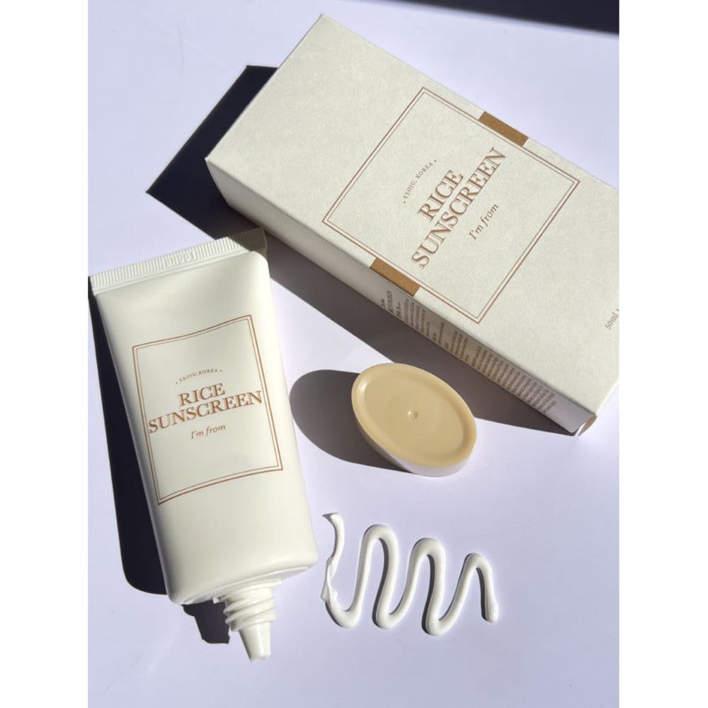 Tubo crema, scatola e coperchio. Scritta « Rice Sunscreen » e « I'm from ». Filo di crema.