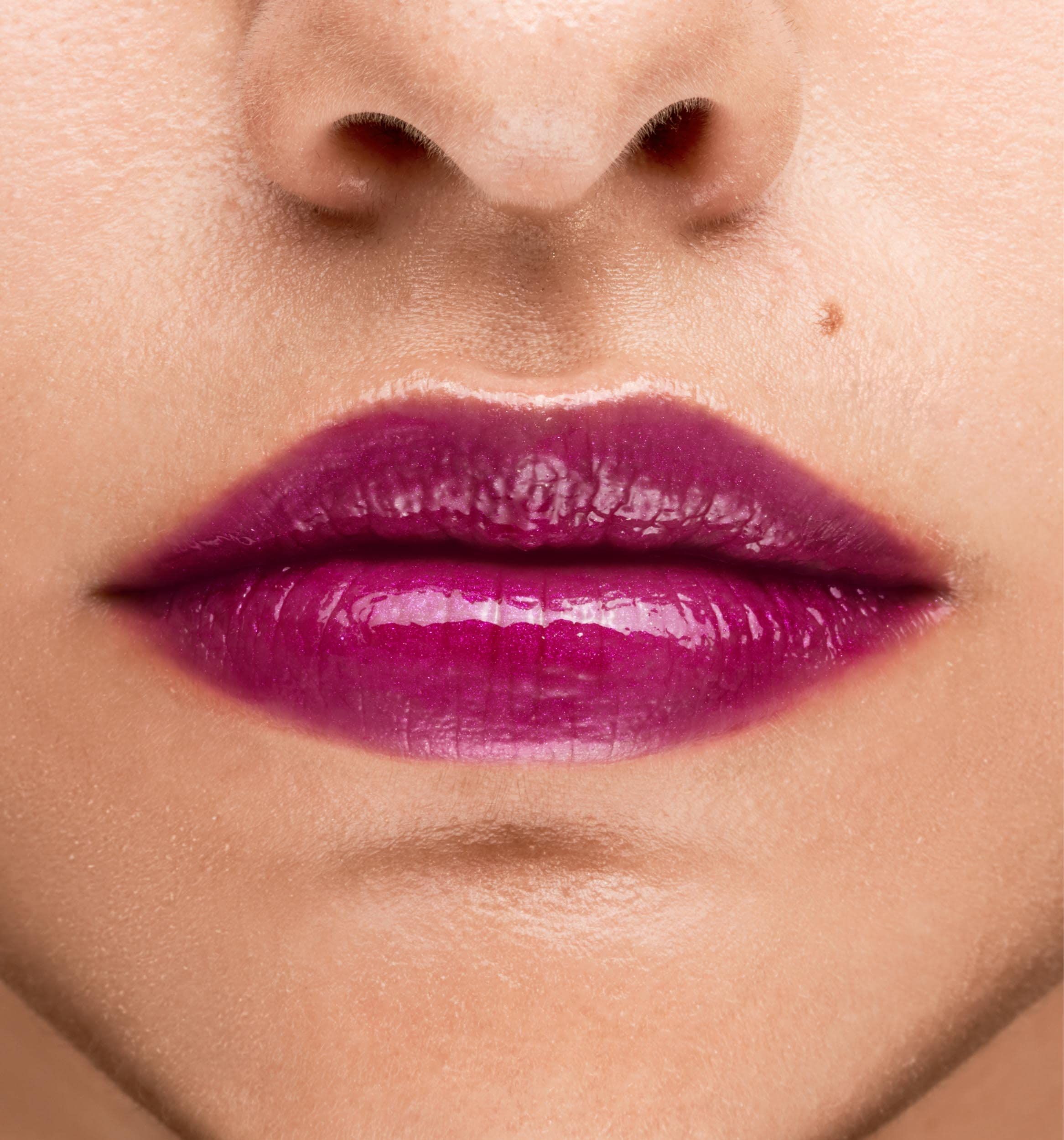 Primo piano di labbra truccate con rossetto rosa. Pelle con lentiggine.