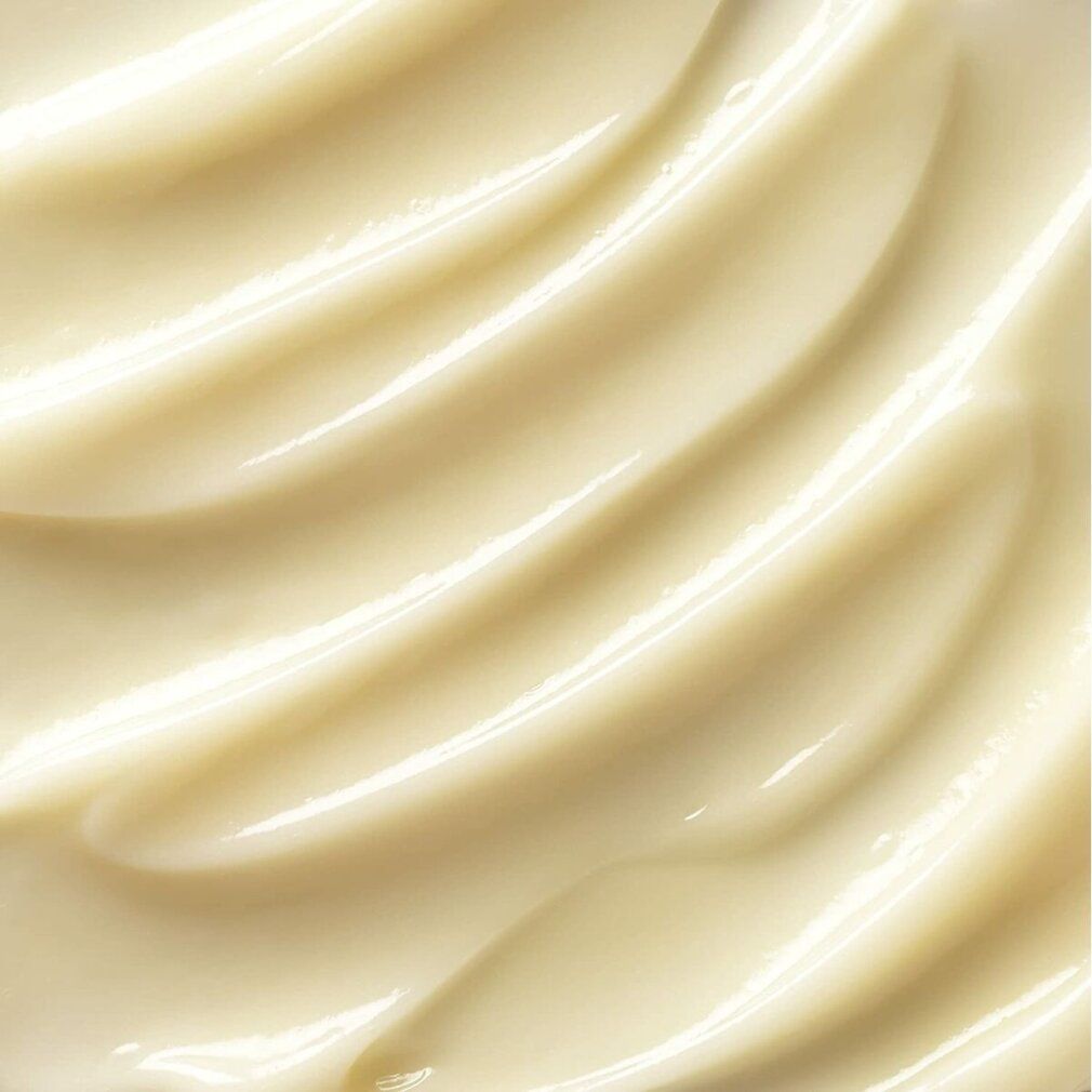 Primo piano della consistenza della crema. Superficie ondulata, color crema. Texture lucida e liscia.