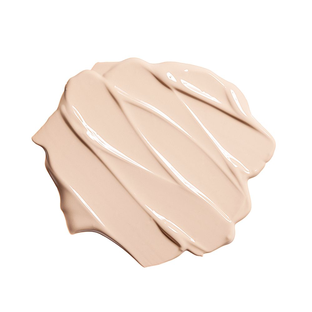 Texture chiara di BB cream striata su sfondo bianco.