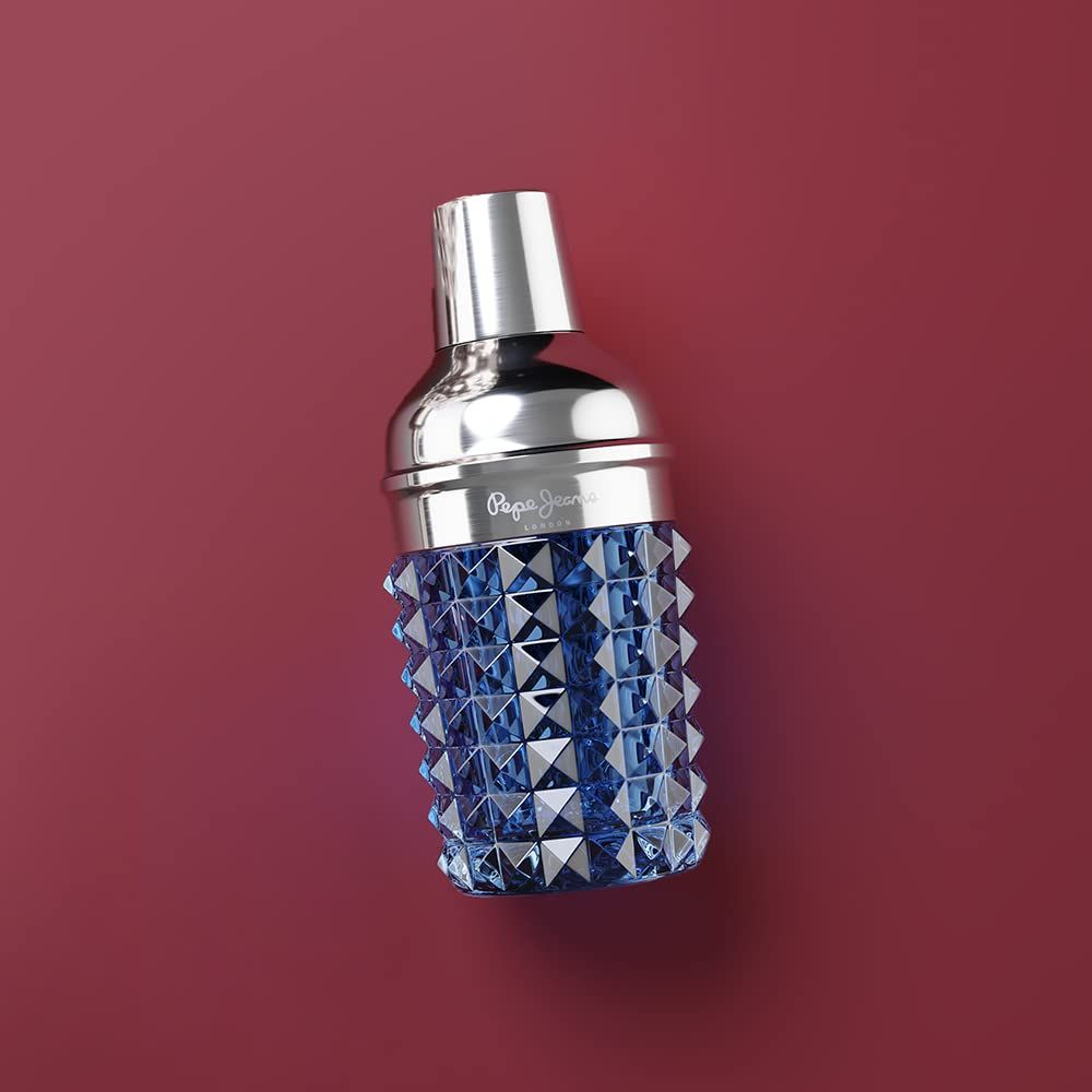 Flacone di profumo blu con tappo argentato. Il flacone ha una superficie strutturata e il logo "Pepe Jeans London".