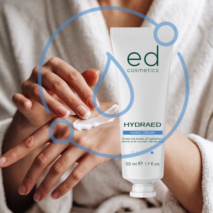 Mani che applicano la crema. Tubo bianco con "ed cosmetics" e "HYDRAED HAND CREAM". 50 ml.