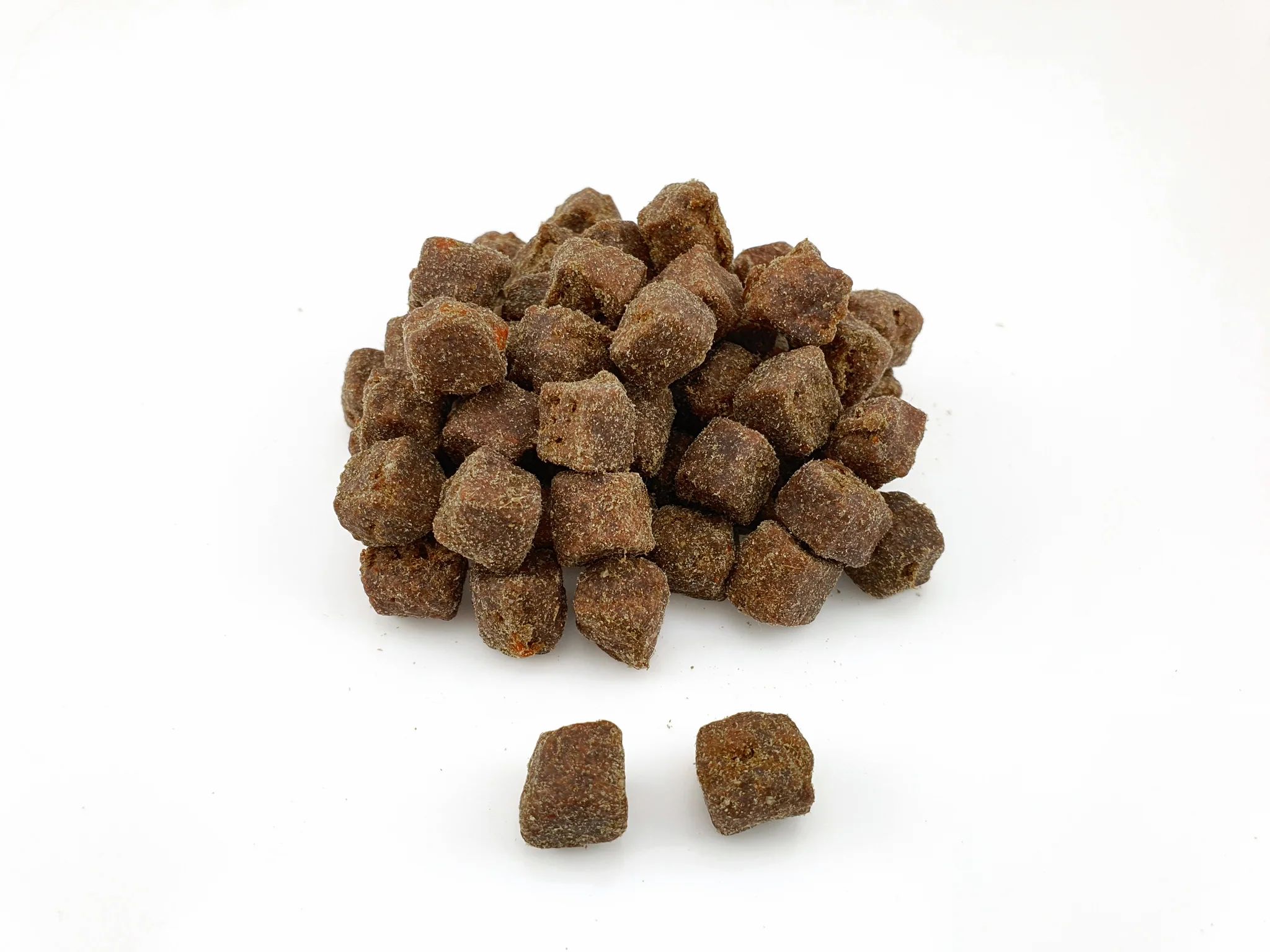 Cumulo di piccoli integratori alimentari marroni a forma di cubo.