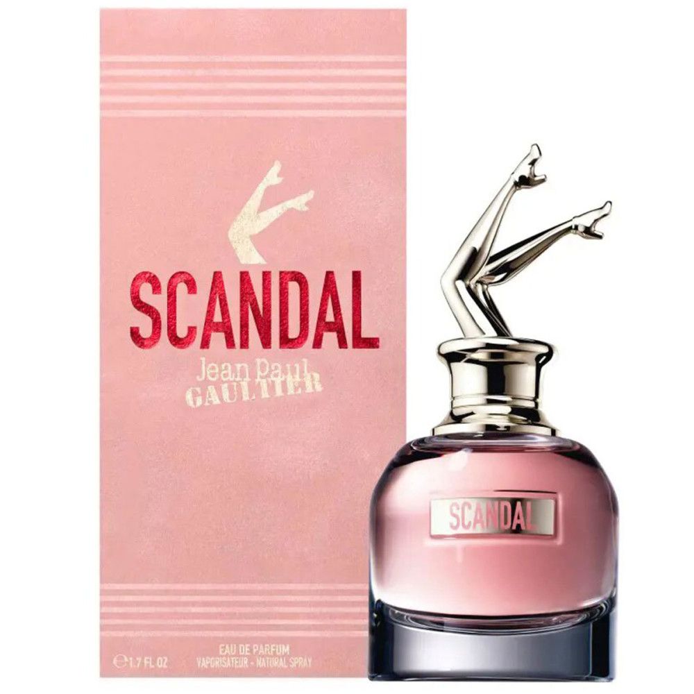 Flacone rosa con tappo dorato a forma di gambe. Scatola rosa con "SCANDAL" e "Jean Paul Gaultier".