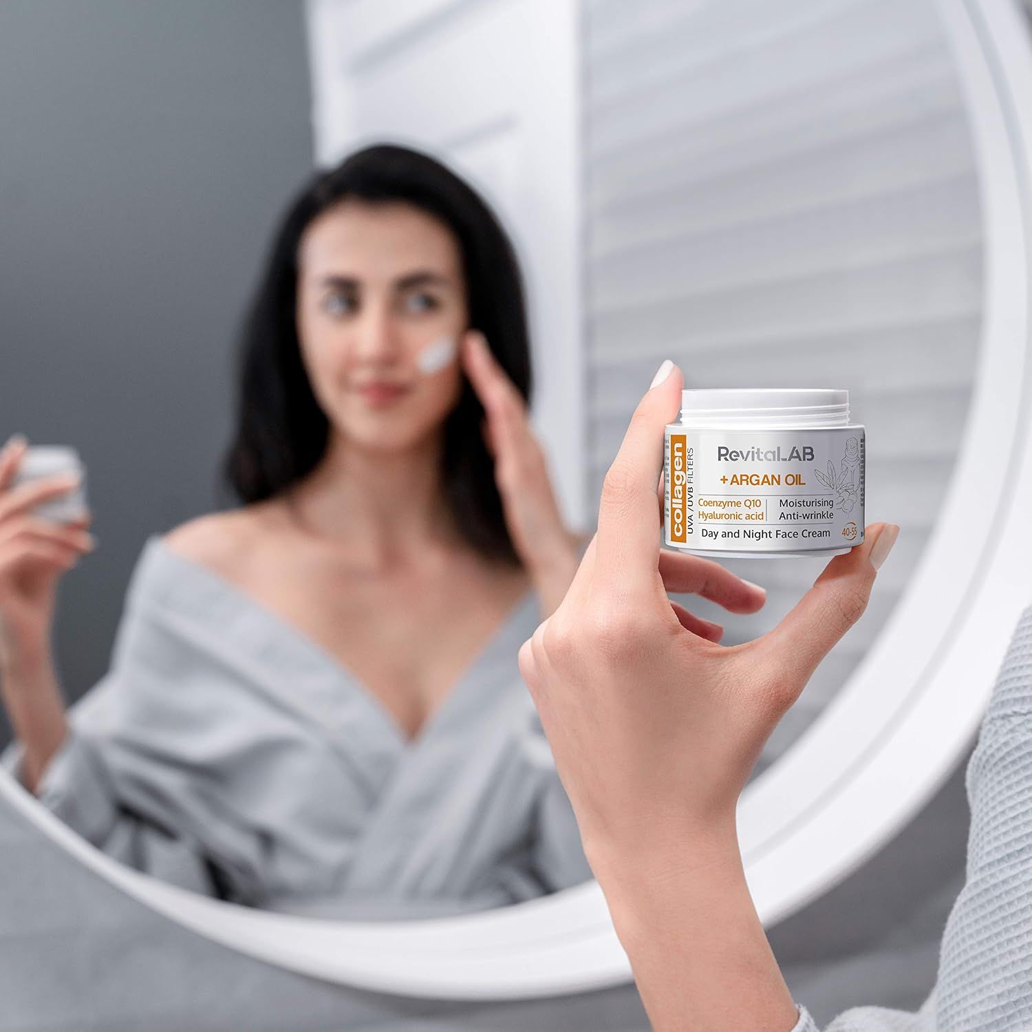 Donna allo specchio con vasetto di crema. Logo RevitaLAB, olio di argan e collagene. Testo: Day and Night Face Cream. 40-55.