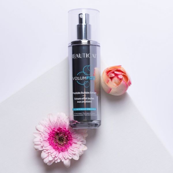 Siero Peptidbubbleserum Volumfizz di Beautical. Flacone argento con vaporizzatore. Nome e dettagli del prodotto sull'etichetta. Con fiori.