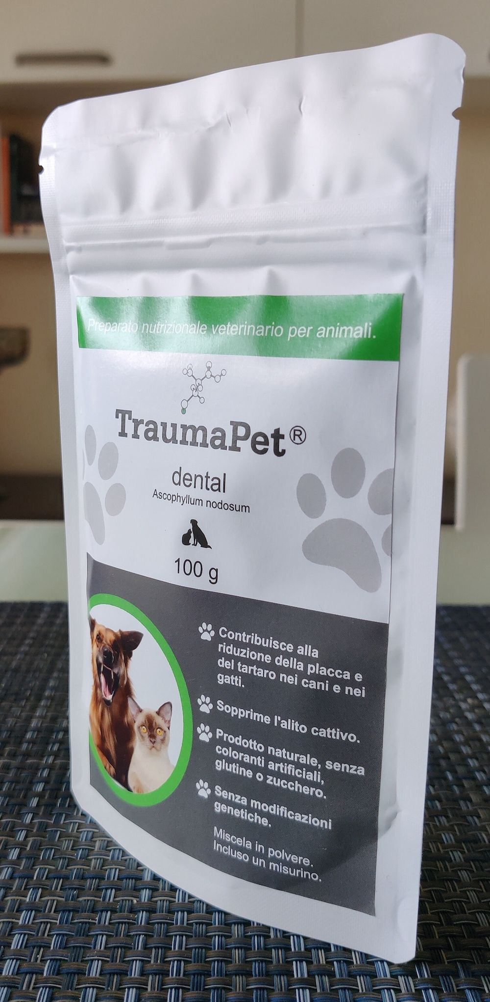 Busta con stampa. Testo: TraumaPet dental, 100g, con cane e gatto. Contiene informazioni sulla riduzione di placca e tartaro.