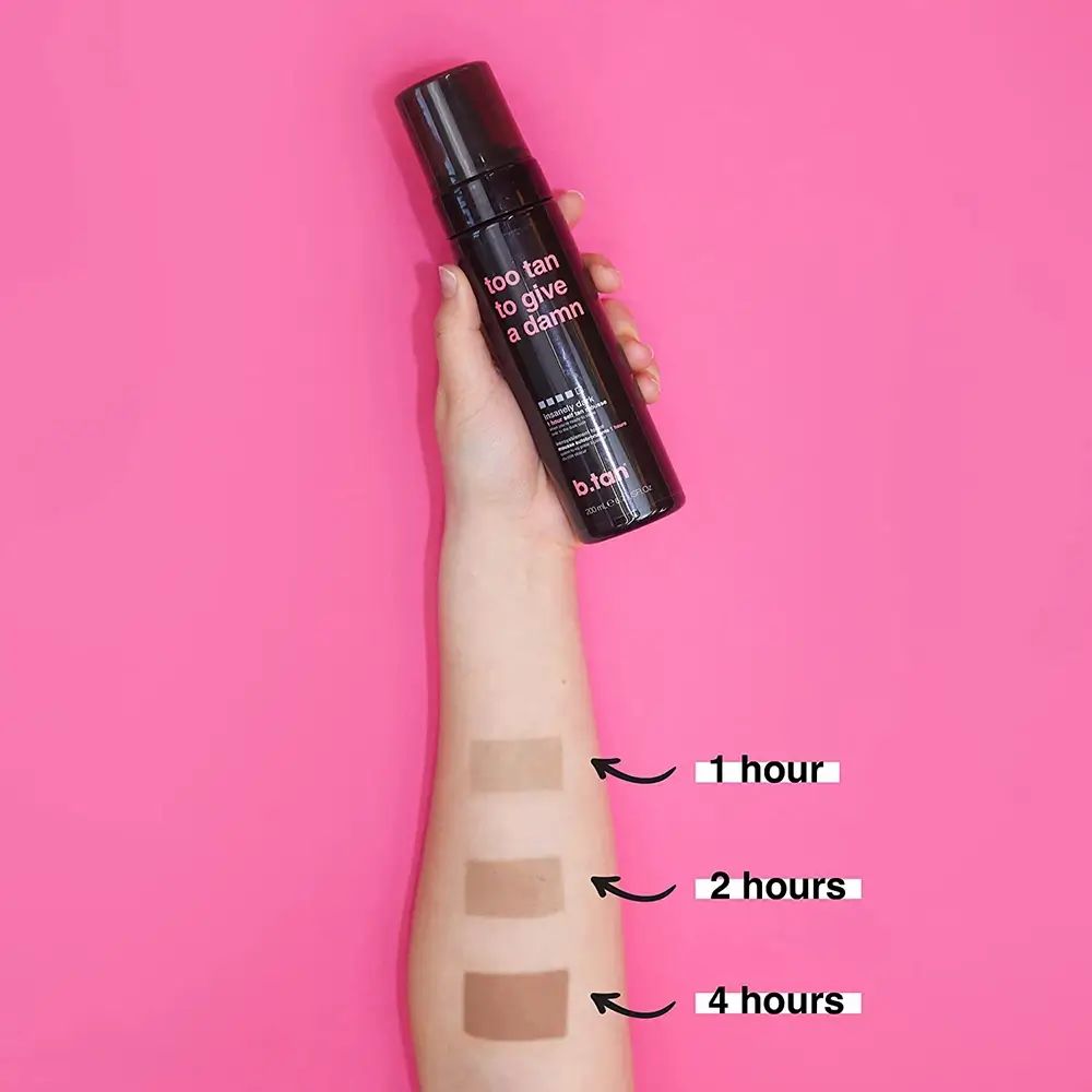 Braccio con strisce abbronzate. Flacone nero con testo. Scritta: too tan to give a damn.
