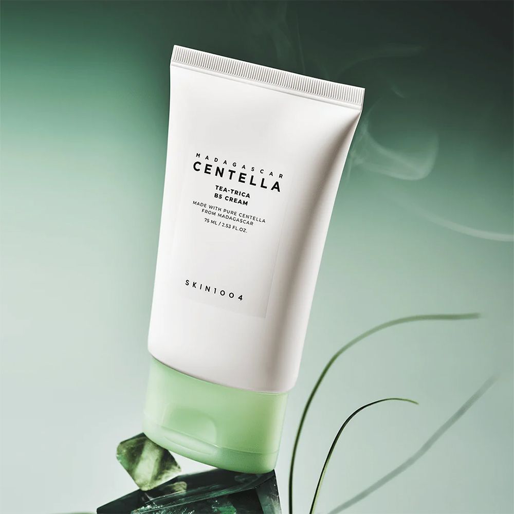Tubo SKIN1004 Centella Tea-Trica B5 Cream su pietre verdi.