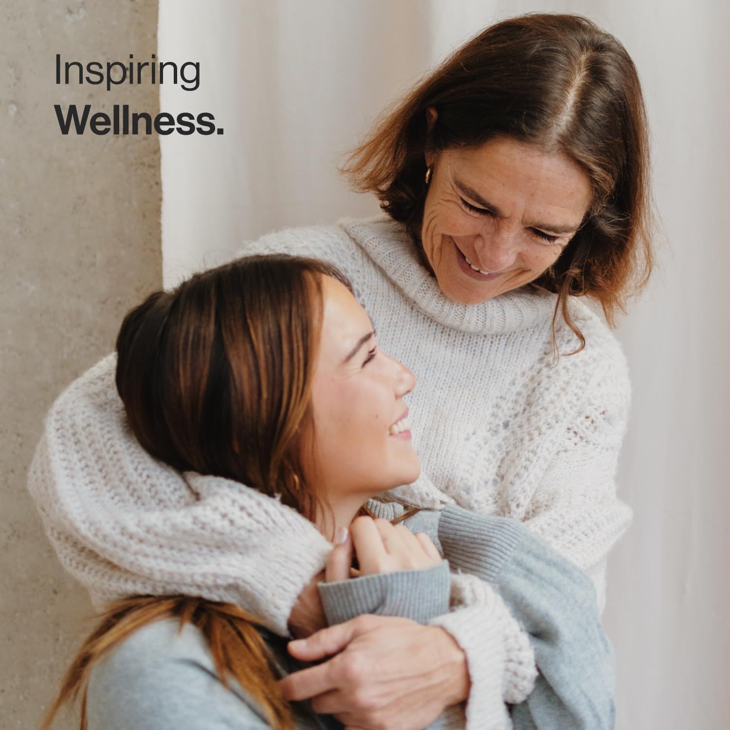 Due donne si abbracciano. Testo: Inspiring Wellness.