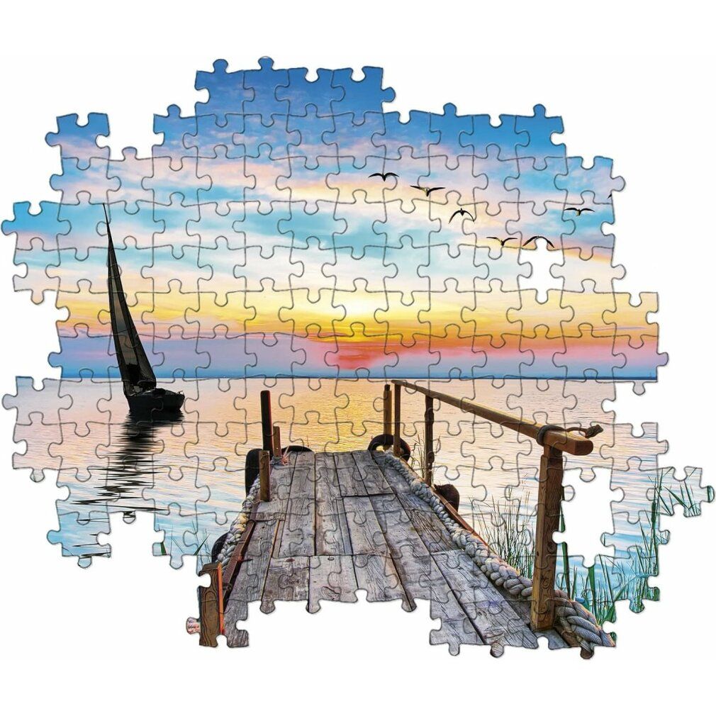 Puzzle assemblato da 500 pezzi. Immagine di lago con barca a vela, pontile e tramonto. Senza cornice.