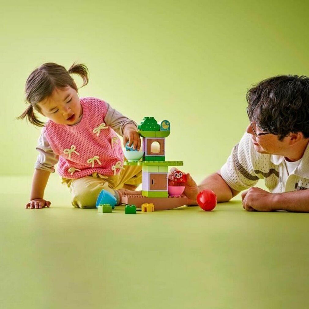 Bambino che gioca con LEGO DUPLO 10440. Un adulto aiuta. Il set include un albero da bilanciare e impilare.