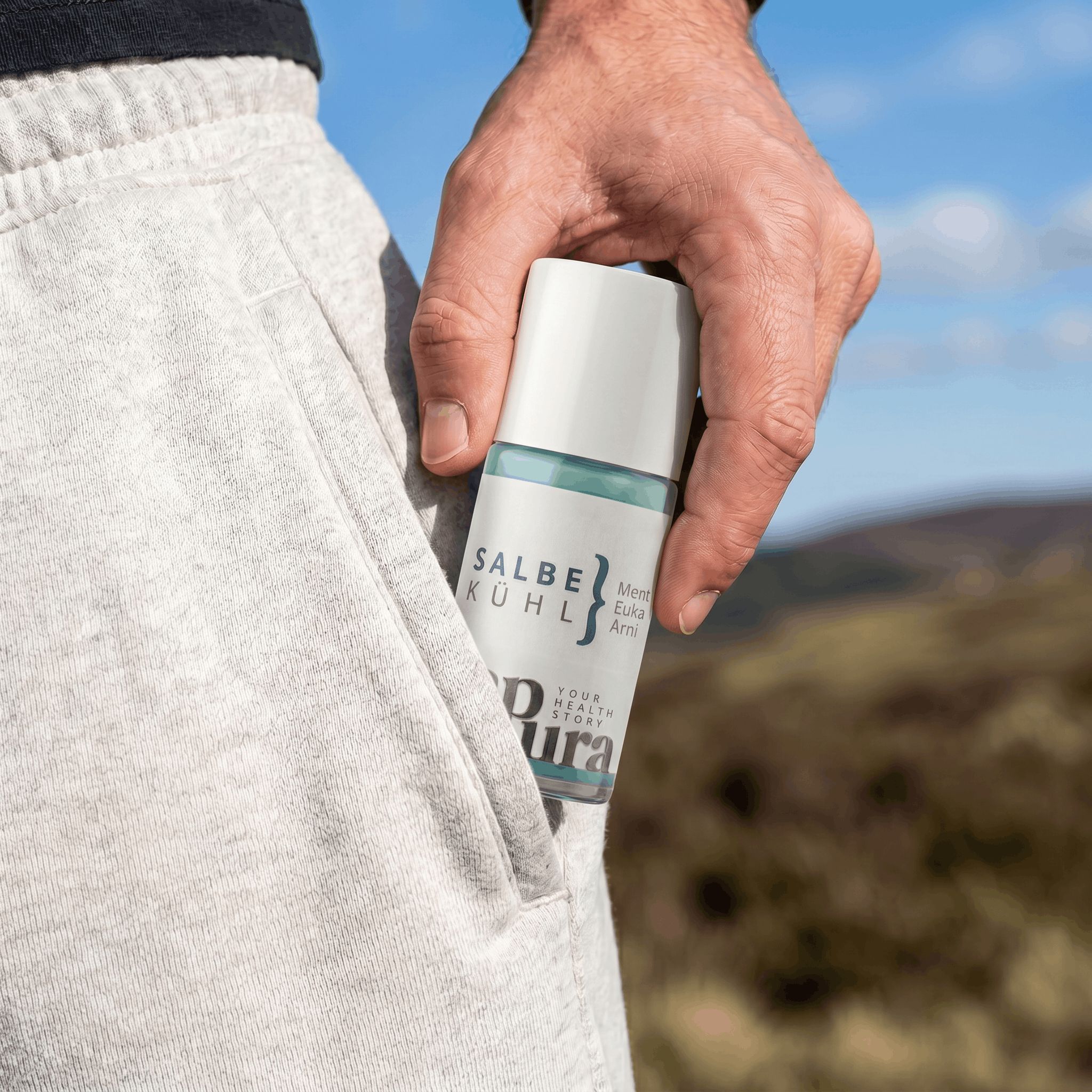 Mano inserisce il gel rinfrescante roll-on sapura health® nella tasca di un pantalone.