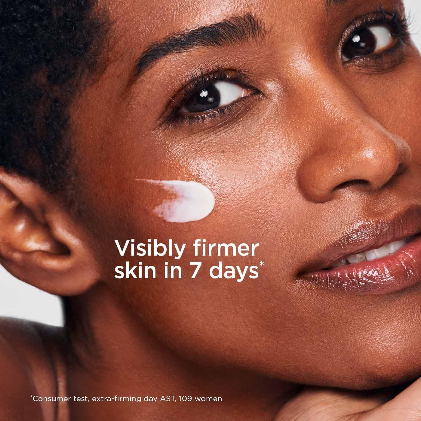 Crema applicata sul viso. Testo: Visibly firmer skin in 7 days. Test consumatori, extra-firming day AST, 109 donne.