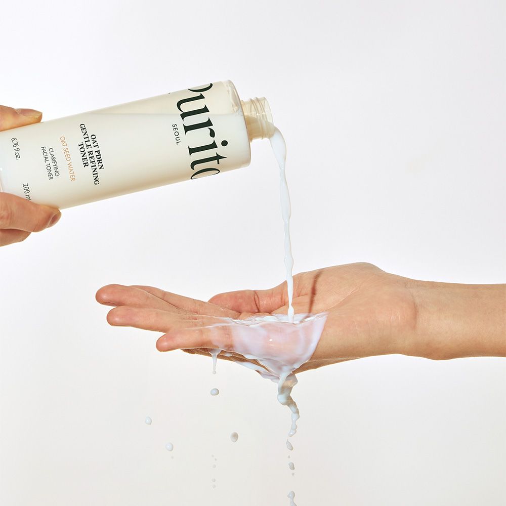 Liquido versato da una bottiglia Purito nel palmo di una mano.