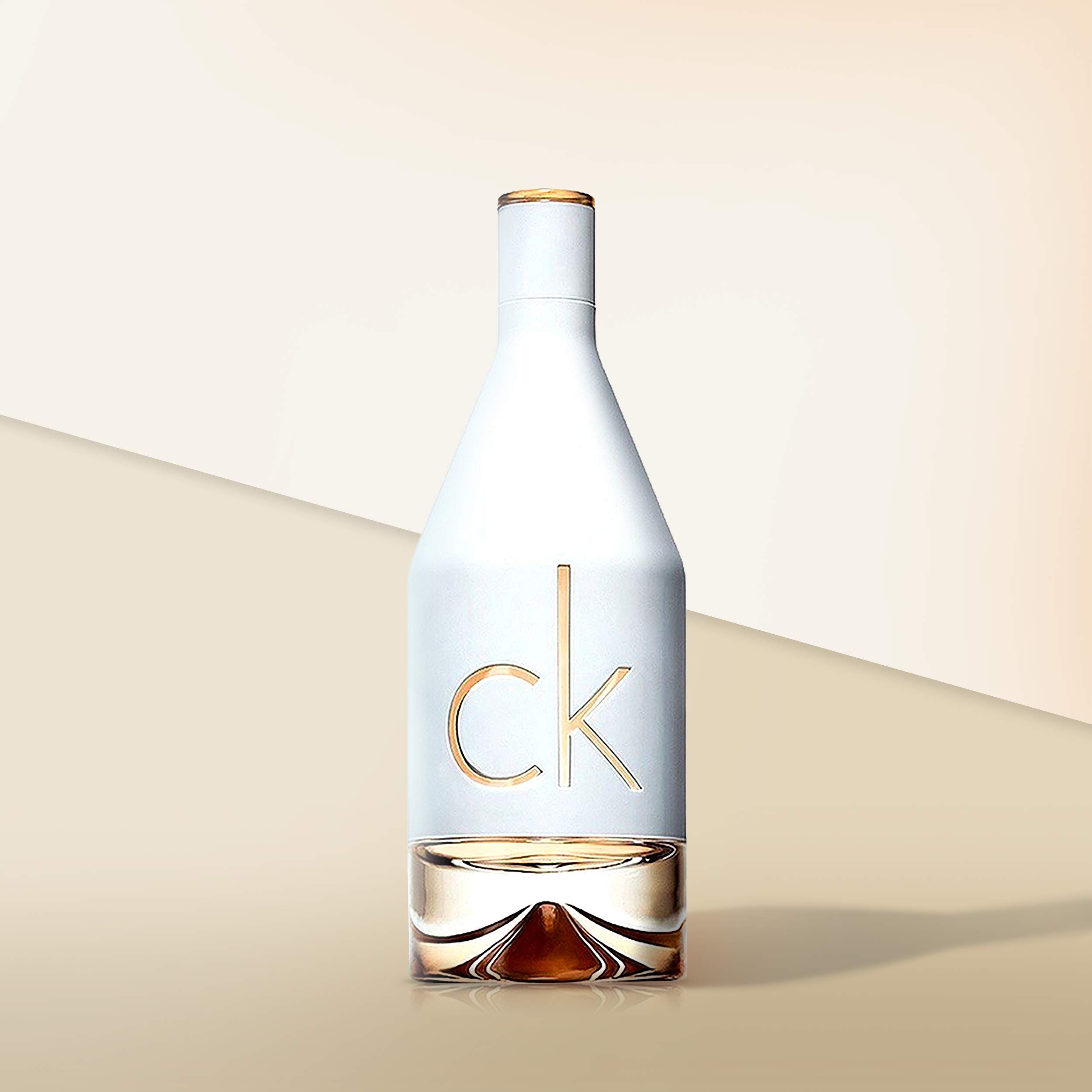 Flacone di profumo Calvin Klein In2u, vetro bianco, scritta dorata. Base riempita di liquido. Logo CK.