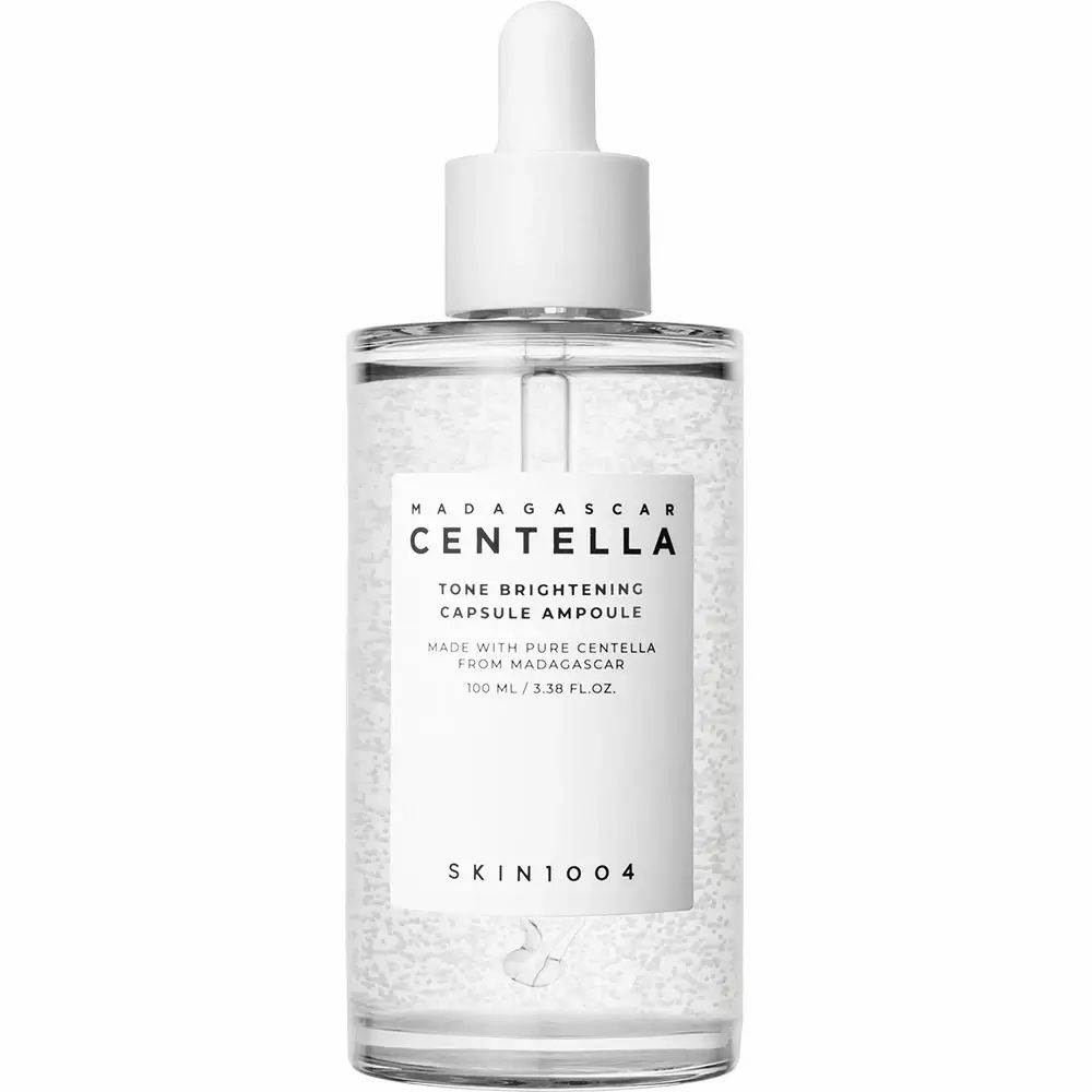 Flacone di vetro trasparente con contagocce. Scritta: CENTELLA, TONE BRIGHTENING CAPSULE AMPOULE. Logo SKIN1004.