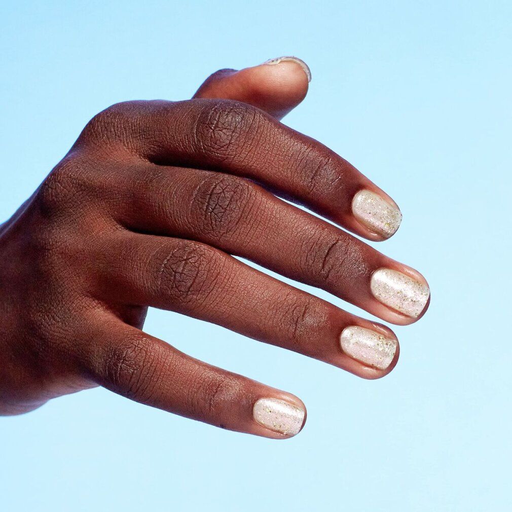 Mano con unghie smaltate. Smalto con glitter.