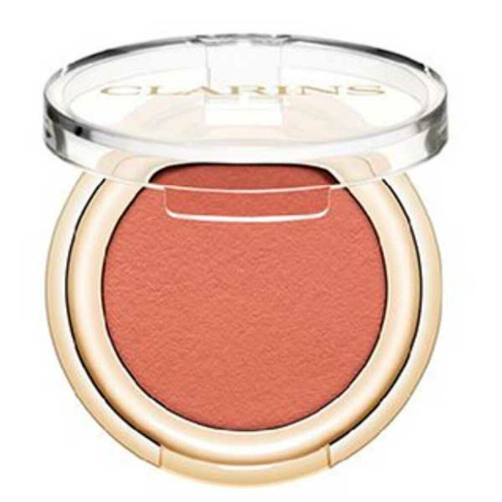 Contenitore rotondo di ombretto con ombretto rosa-marrone. Coperchio aperto. Bordo dorato. Coperchio trasparente con logo.