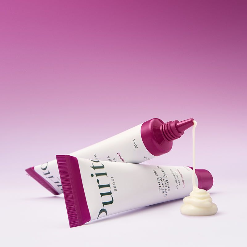 Due tubi di crema PURITO. La crema fuoriesce da un tubo. Sfondo viola.