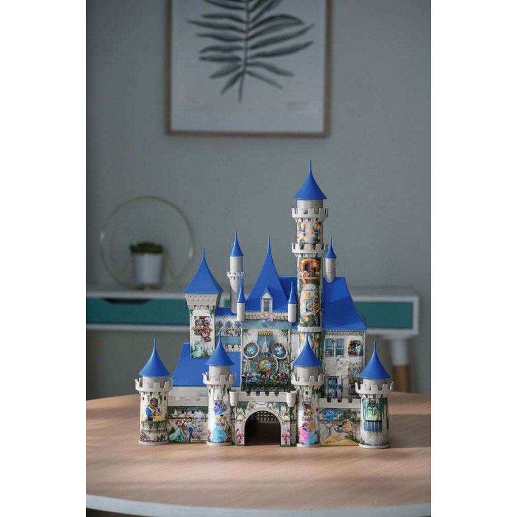 Puzzle 3D Disney Castello assemblato su tavolo. Castello blu e bianco con personaggi Disney. Sfondo: stanza.