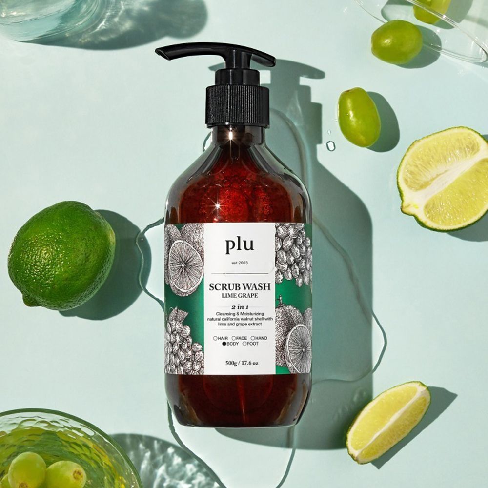 Flacone marrone con erogatore nero. Scritta: PLU Scrub Wash Lime Grape. Lime e uva accanto.
