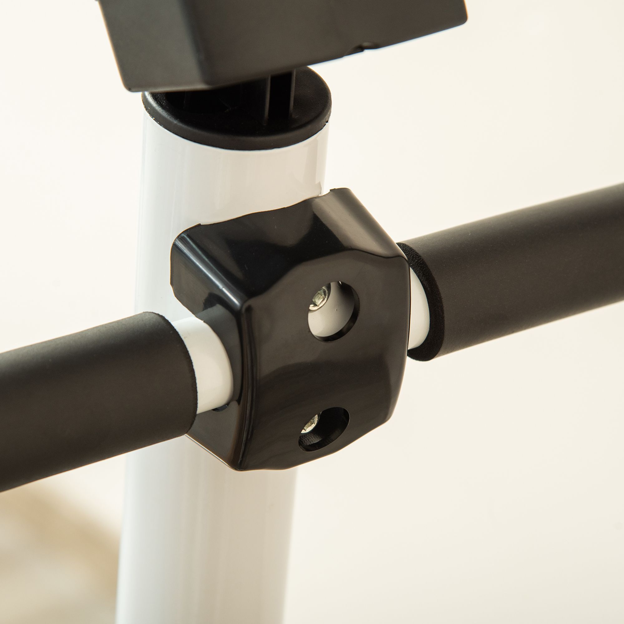 Dettaglio del manubrio dello stepper. Manubrio nero, metallo bianco. Elemento di connessione.