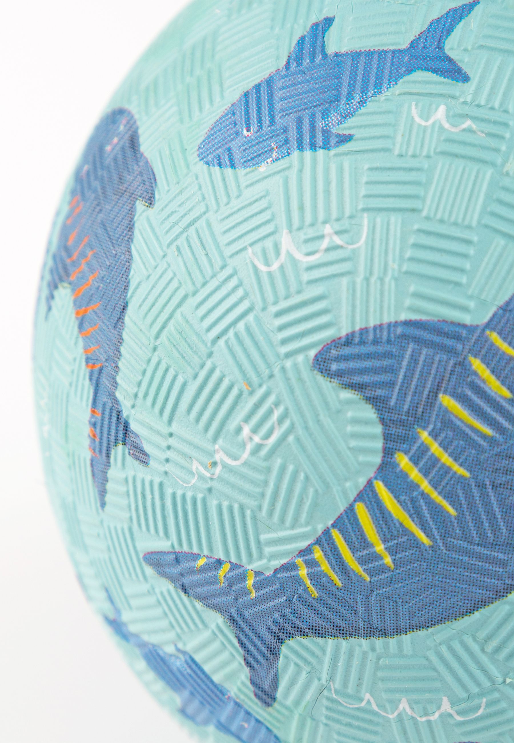 Primo piano di una palla blu con motivo a squalo. Diversi squali di diverse dimensioni e colori.