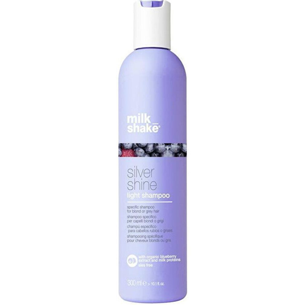 Flacone di shampoo. Flacone viola con tappo bianco. Scritta: Milk Shake, Silver Shine Light Shampoo. Con mirtillo.