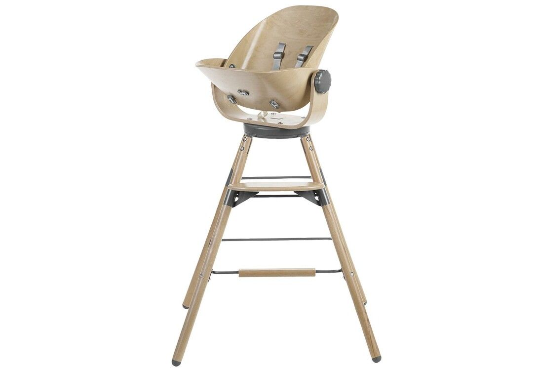 Seggiolino per bambini con struttura in legno. Scocca beige con cinture. Gambe in legno con raccordi metallici. Regolazione laterale.