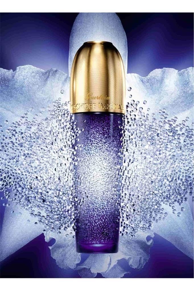 Flacone blu-viola, tappo dorato. Scritta: Guerlain Orchidée Impériale. Circondato da perle bianche.