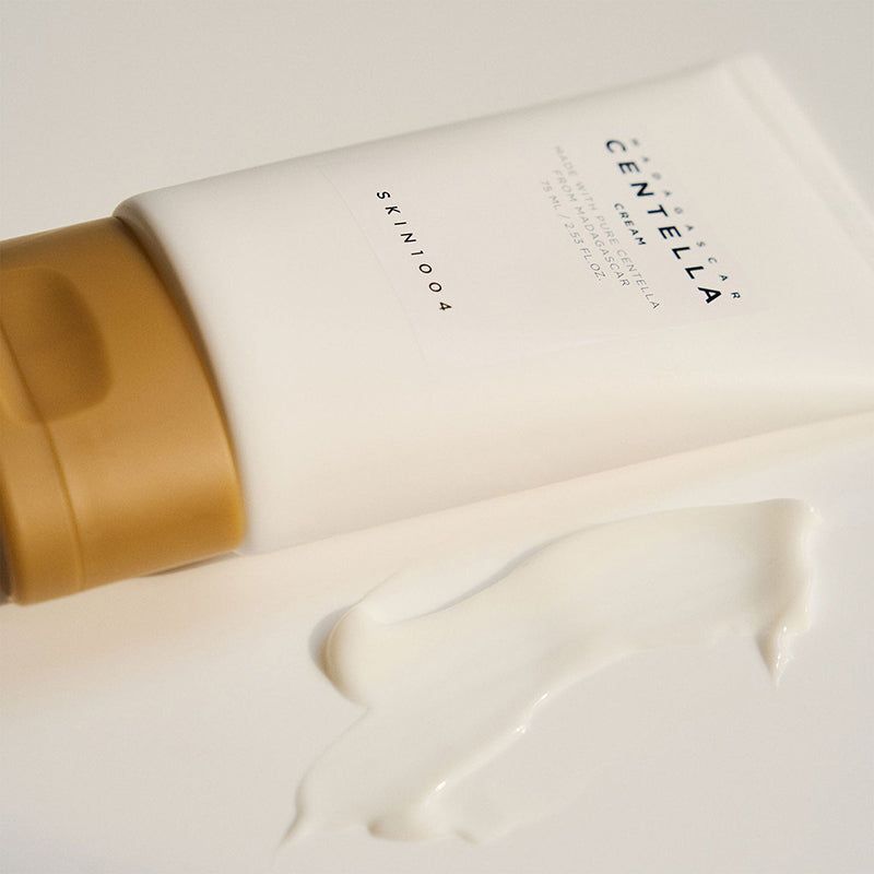 Tubo con crema accanto. Scritta: MADAGASCAR CENTELLA CREAM, SKIN1004. Crema visibile.