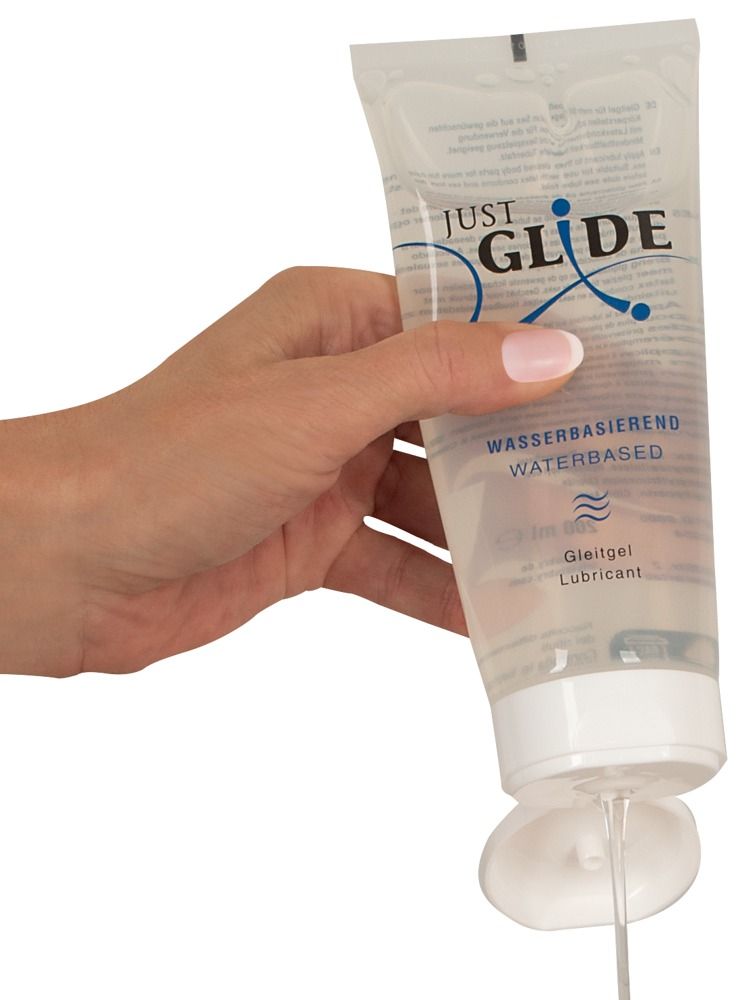 Mano che tiene un tubo di lubrificante Just Glide, con il prodotto che fuoriesce.
