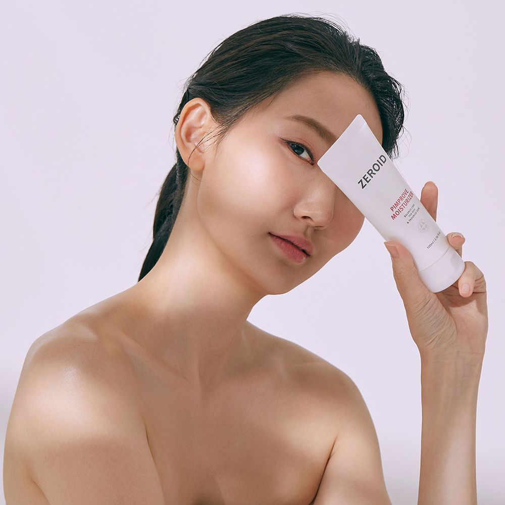 Donna tiene un tubo bianco ZEROID Pimprove Moisturizer davanti al viso. Scritta: Balance Care for Oily & Troubled Skin.