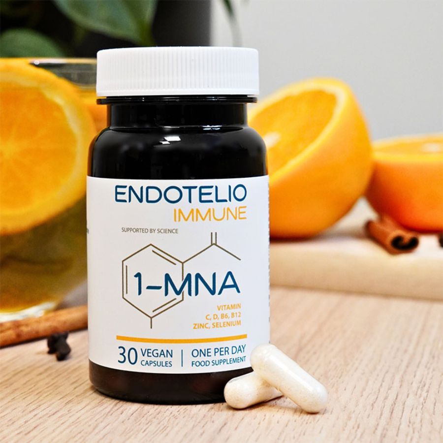 Flacone di capsule marrone con capsule e arance su legno. Nome del prodotto e ingredienti sul flacone. Sfondo giallo.
