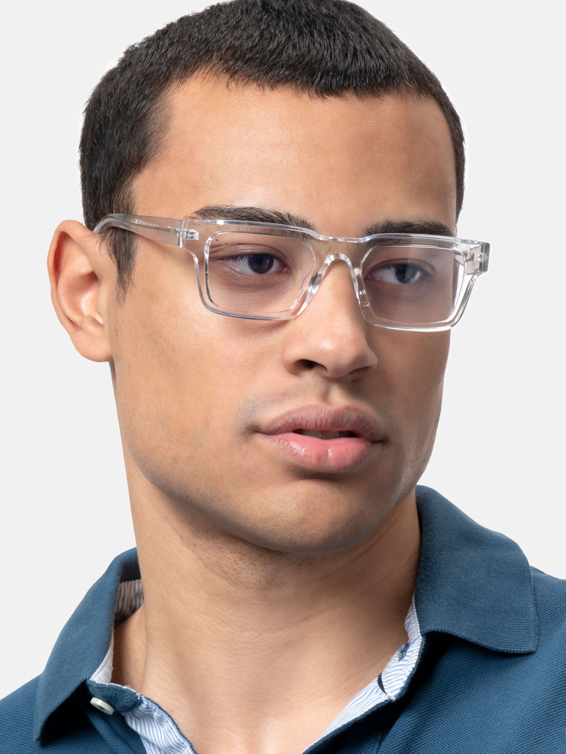 Uomo con camicia blu che indossa occhiali trasparenti.