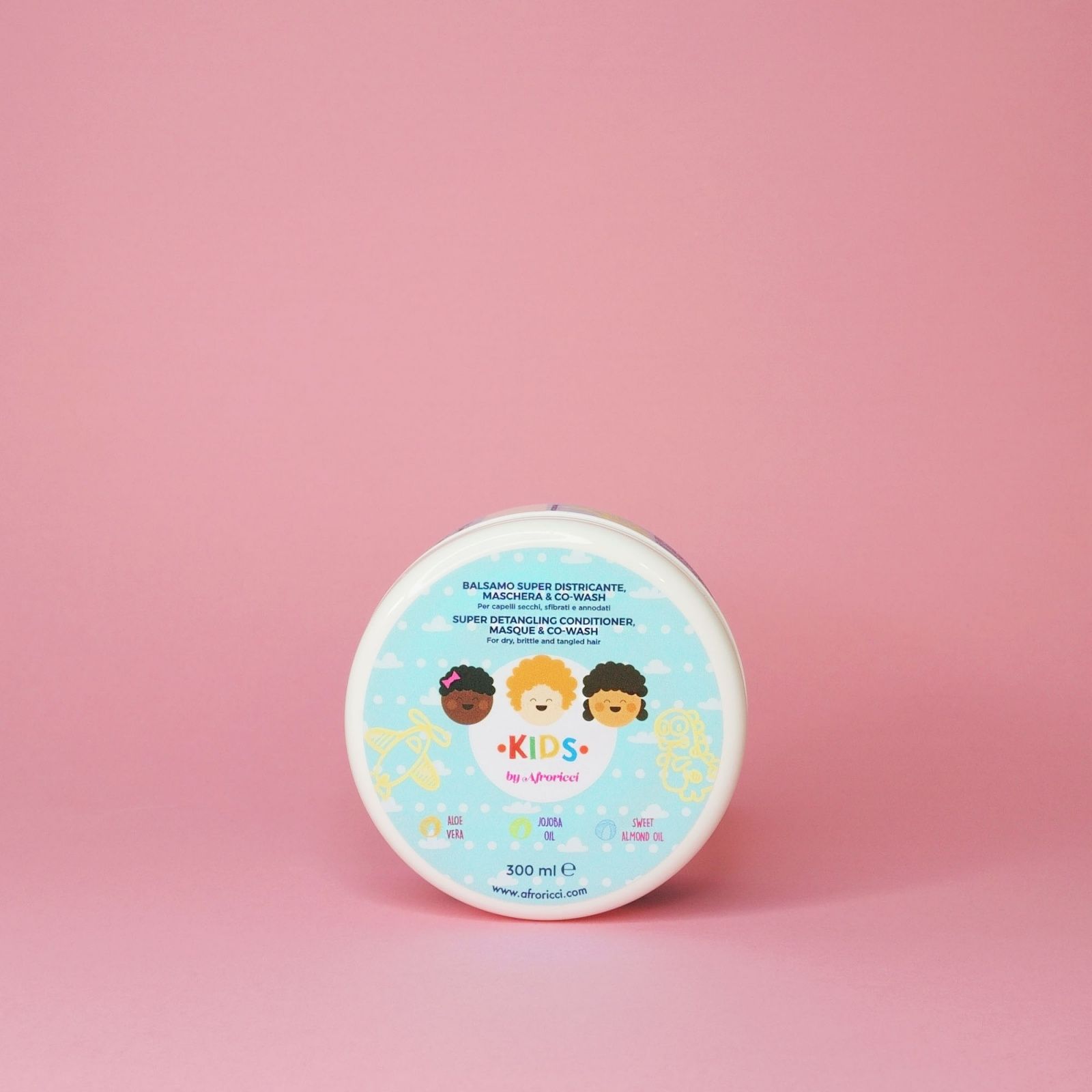 Contenitore rotondo bianco con coperchio blu. Testo: Balsamo Super Districante, Maschera & Co-Wash. 300 ml. Su sfondo rosa.