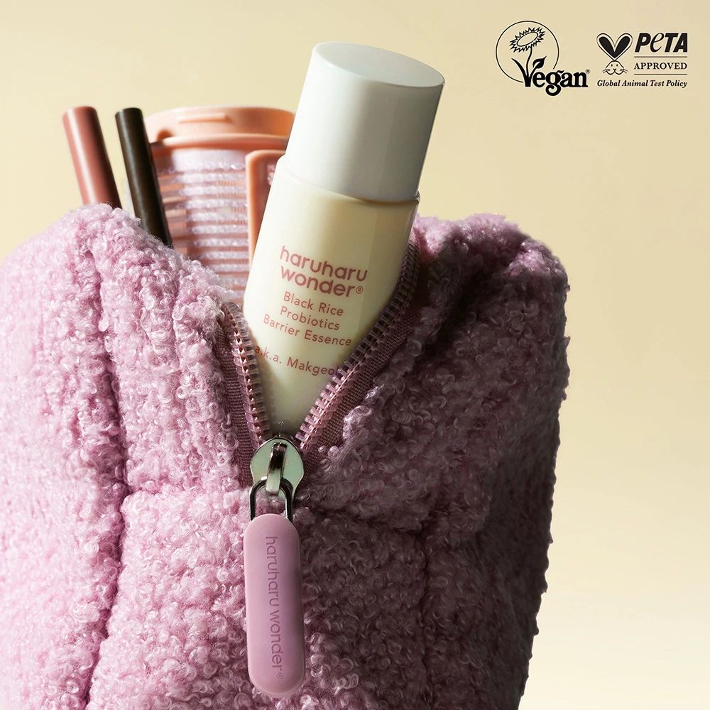 Astuccio cosmetico rosa con zip, con bottiglia HARUHARU WONDER. Sigilli Vegan e PETA.