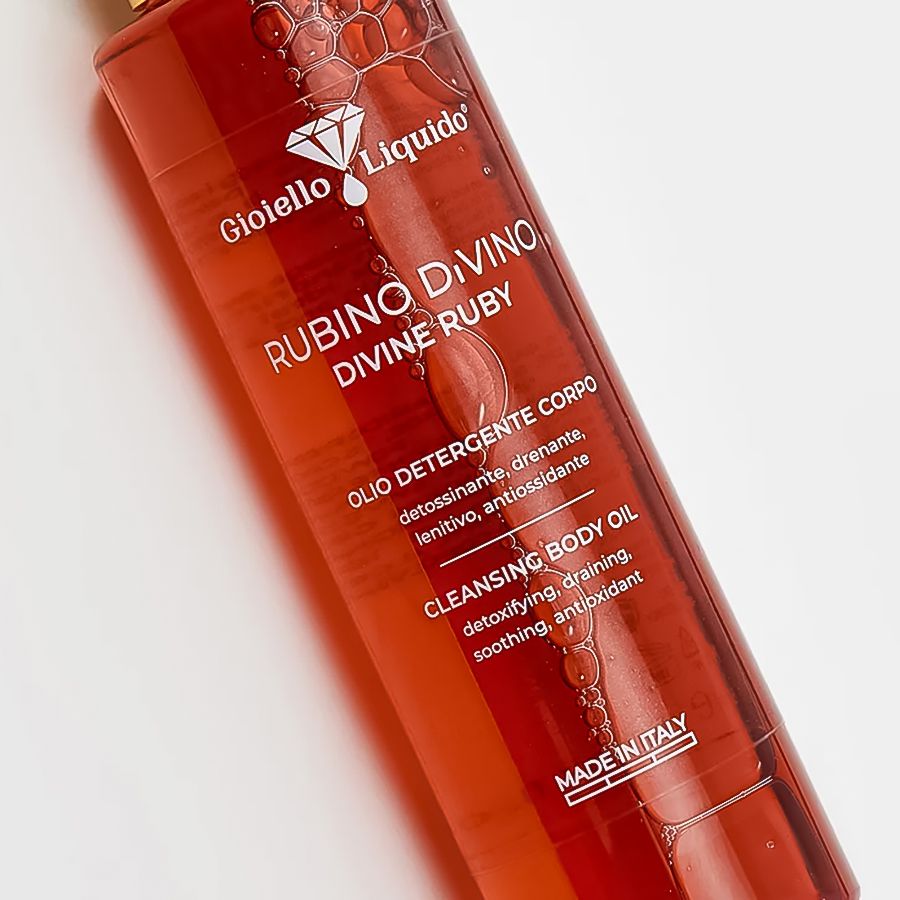 Olio detergente corpo, liquido rosso. Scritta: Rubino Divino Divine Ruby. Tappo dorato. Made in Italy.