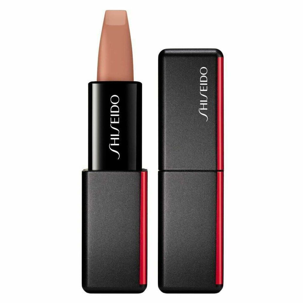 Rossetto con custodia nera e accento rosso. Il rossetto è marrone chiaro. Sulla custodia è scritto "SHISEIDO". Il coperchio è accanto.