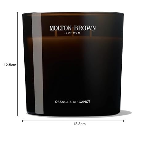 Candela profumata in vetro scuro a tre stoppini. Scritta: Molton Brown London, Orange & Bergamot. Dimensioni: 12,5 cm altezza, 12,3 cm larghezza.