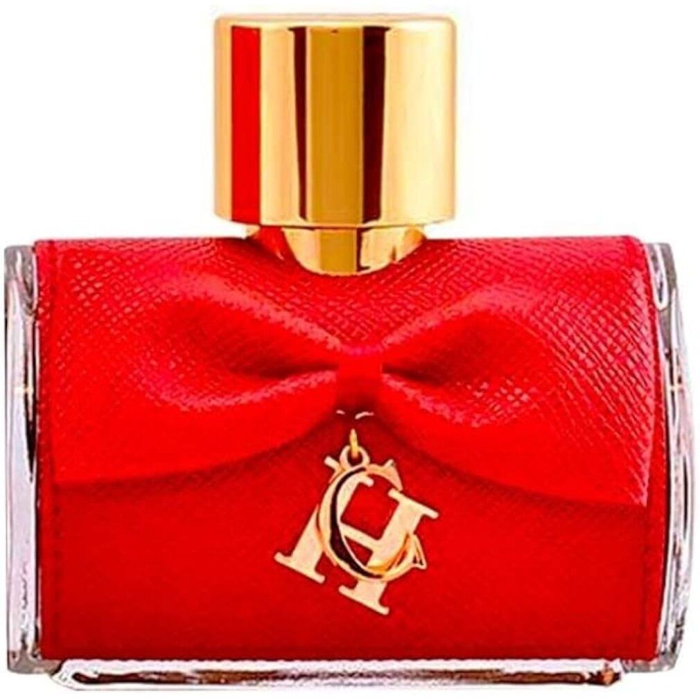 Flacone di profumo con fiocco rosso e ciondolo dorato. Tappo dorato. Forma quadrata.
