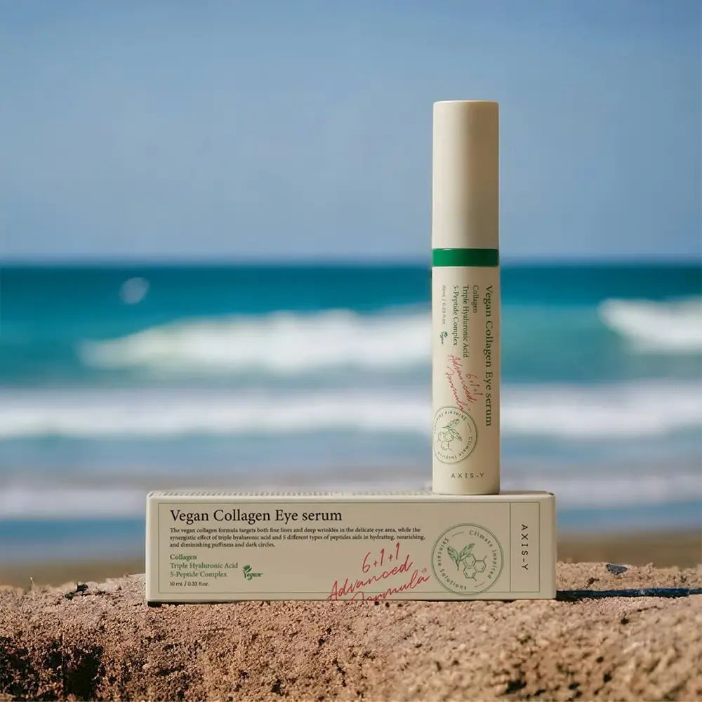 Siero occhi e confezione sulla spiaggia. Testo: Vegan Collagen Eye serum. AXIS-Y. Onde sullo sfondo.