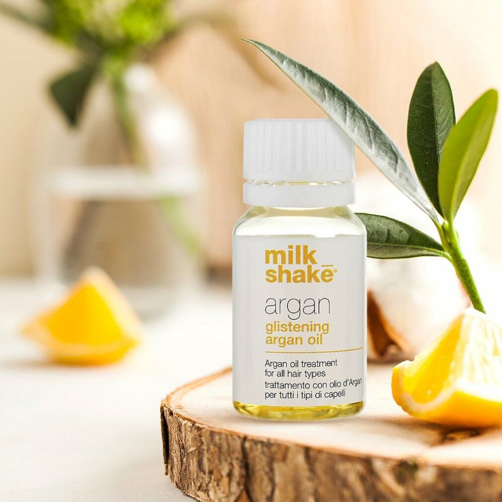 Flacone di vetro con tappo bianco su tavola di legno. Scritto: Milk_shake, Argan Glistening Argan Oil. Decorazione.