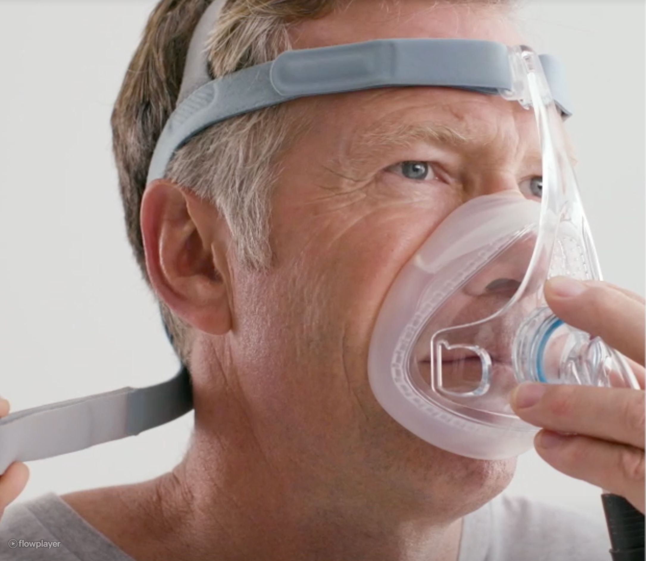 Uomo che indossa una maschera CPAP dormendo. Diverse immagini sovrapposte mostrano il movimento.