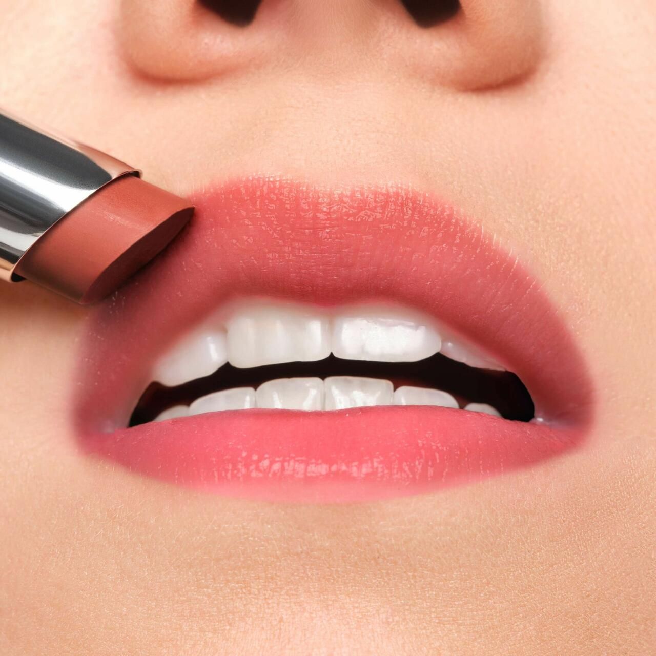 Primo piano di labbra truccate con un balsamo per labbra. Le labbra sono tinte di rosa.