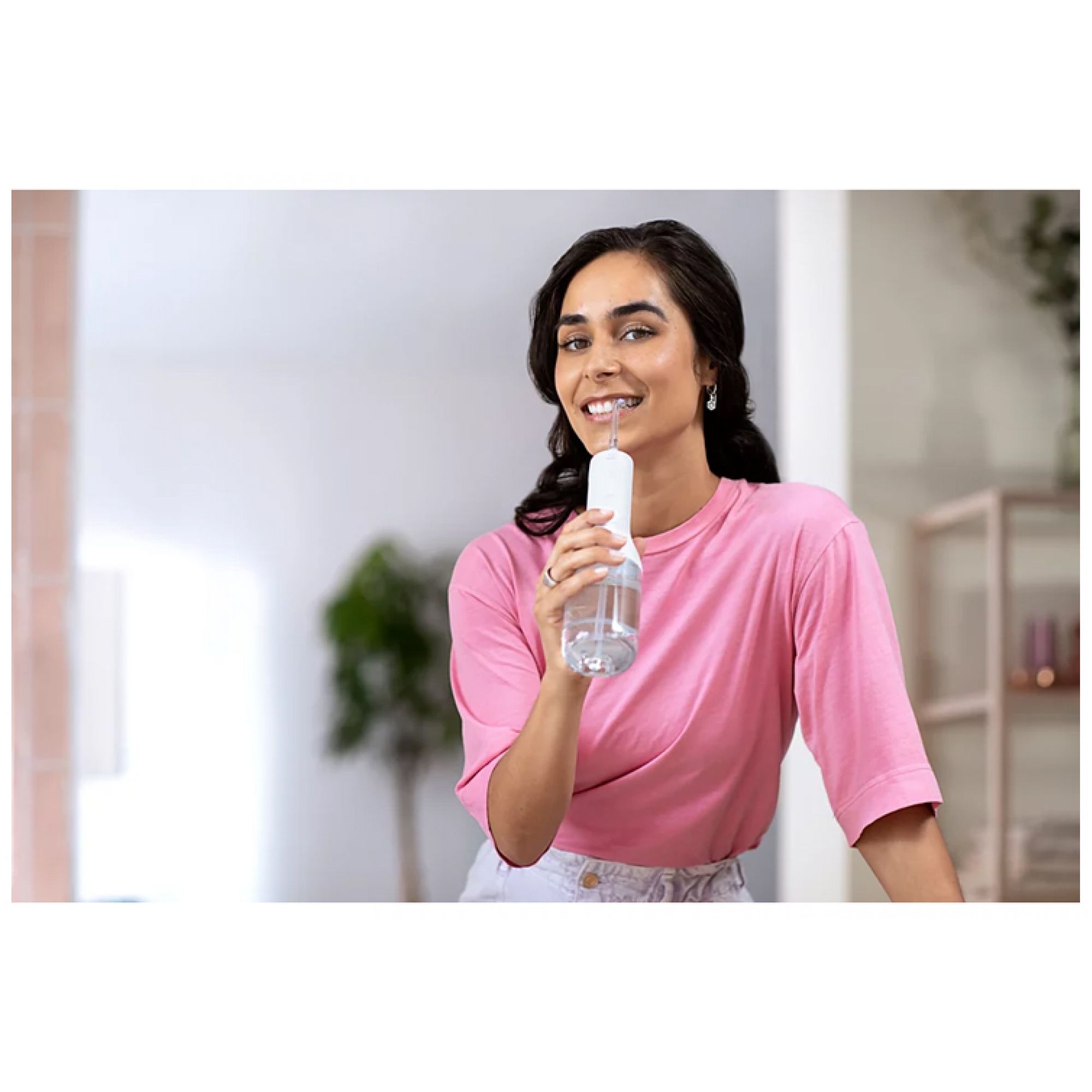 Donna tiene idropulsore con serbatoio d'acqua.